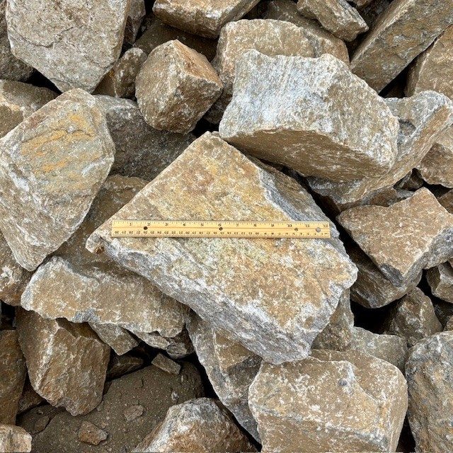 Colorado Sunset rip rap. Large angular tan and grey rock for erosion control.